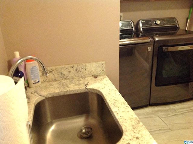 laundry room featuring sink, light tile patterned floors, and independent washer and dryer