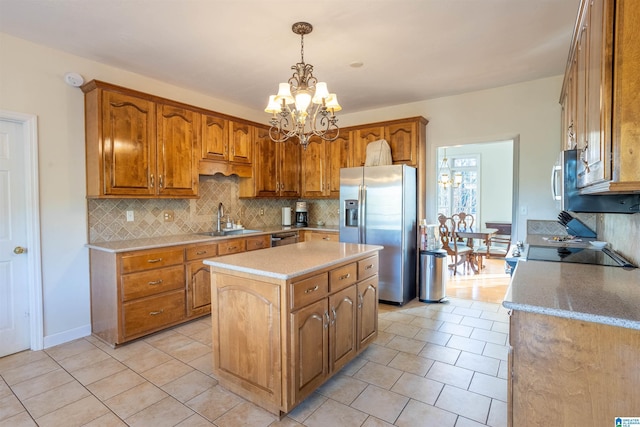 kitchen with stainless steel appliances, sink, light tile patterned floors, decorative light fixtures, and a center island