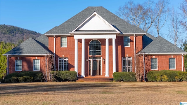 view of front facade featuring a mountain view and a front lawn