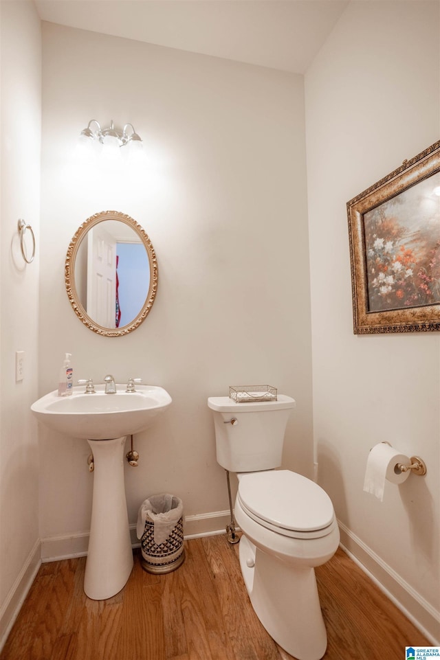 bathroom with hardwood / wood-style flooring and toilet