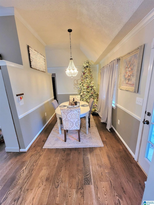 dining space featuring ornamental molding, a textured ceiling, a notable chandelier, dark hardwood / wood-style floors, and lofted ceiling