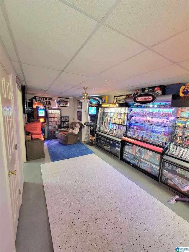 recreation room with a paneled ceiling and ceiling fan