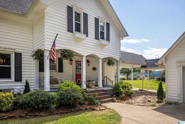 doorway to property with a yard and a porch