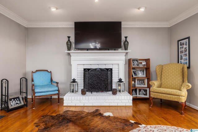 living room featuring hardwood / wood-style floors, ornamental molding, and a brick fireplace