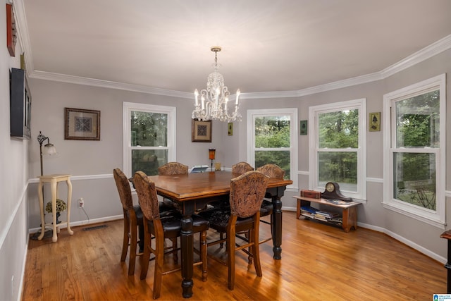 dining space featuring a chandelier, light hardwood / wood-style floors, and crown molding