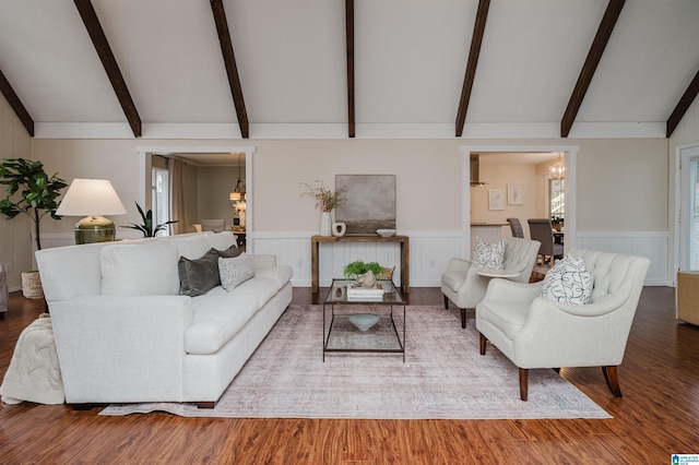 living room featuring vaulted ceiling with beams and hardwood / wood-style floors