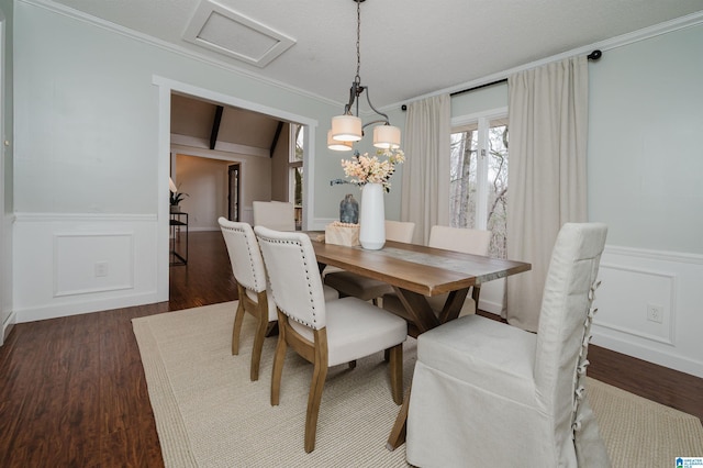 dining space with dark hardwood / wood-style flooring, an inviting chandelier, and crown molding