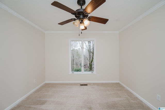 spare room with ceiling fan, light colored carpet, and crown molding