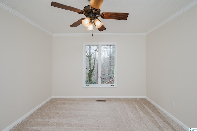 carpeted spare room with ceiling fan and ornamental molding