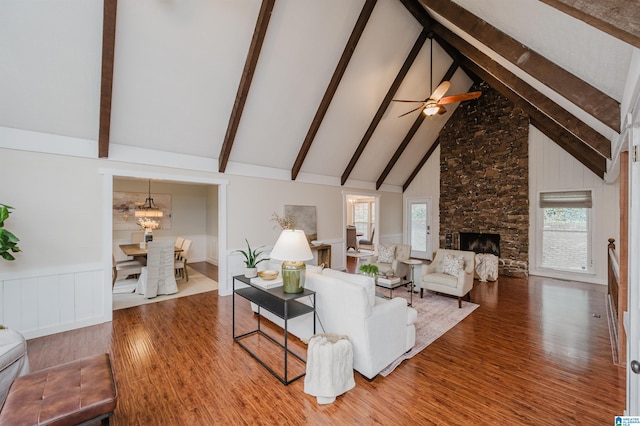 living room featuring plenty of natural light, a fireplace, high vaulted ceiling, and beamed ceiling