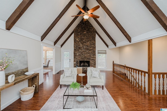 living room with beamed ceiling, a healthy amount of sunlight, and high vaulted ceiling