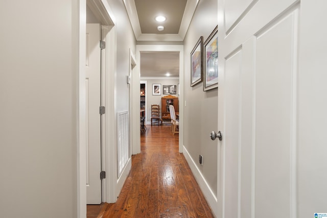 corridor with dark hardwood / wood-style floors and ornamental molding