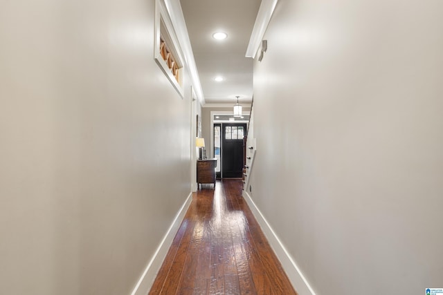 corridor with dark hardwood / wood-style floors and crown molding