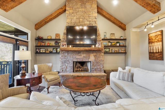 living room with beam ceiling, a stone fireplace, rail lighting, and high vaulted ceiling