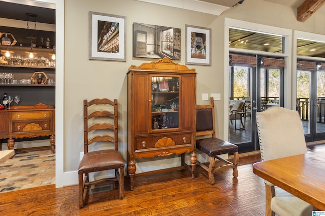 living area with beam ceiling, dark hardwood / wood-style flooring, and french doors