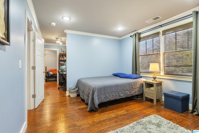 bedroom with ornamental molding and dark wood-type flooring