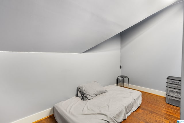 bedroom with hardwood / wood-style floors and vaulted ceiling