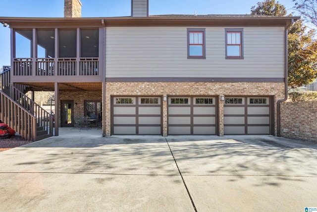 view of front of property with a sunroom, a patio area, and a garage