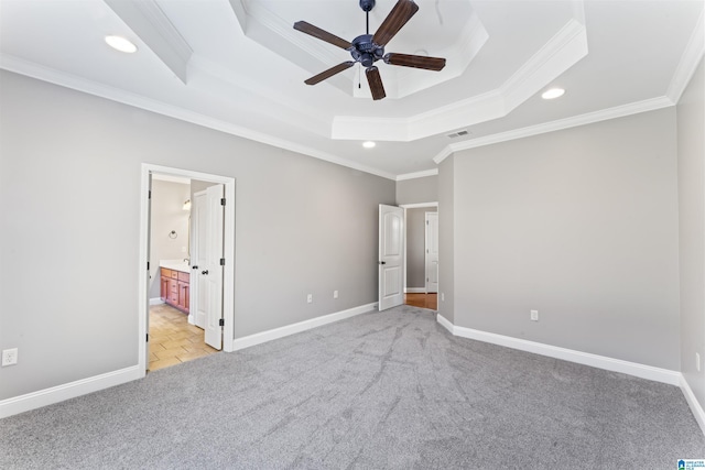 unfurnished bedroom with ensuite bathroom, ceiling fan, a raised ceiling, and crown molding