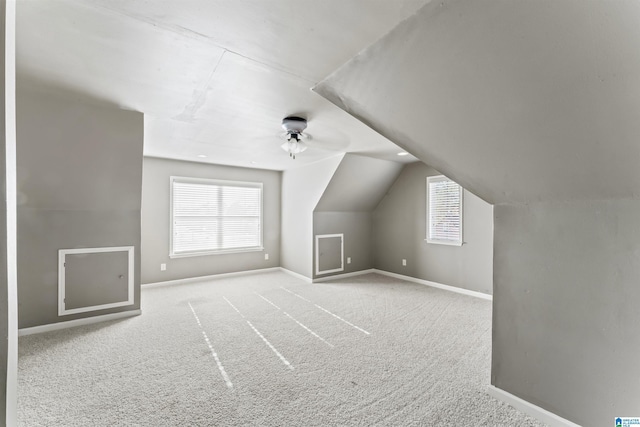 bonus room with light carpet and vaulted ceiling