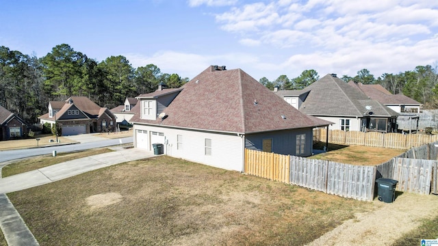 view of side of property featuring a garage and a lawn