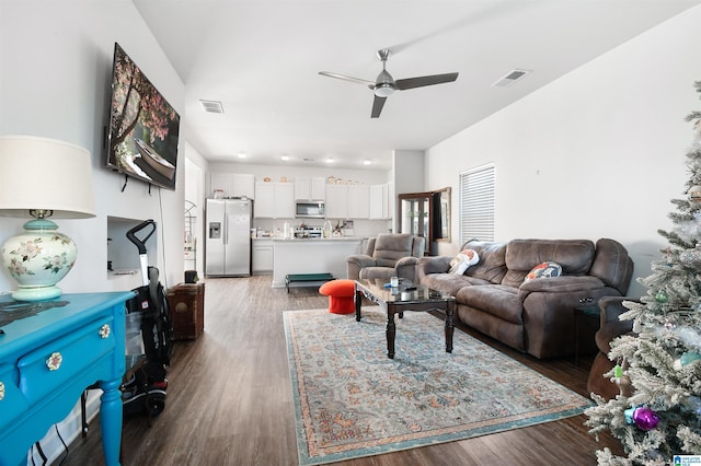 living room featuring ceiling fan and dark wood-type flooring