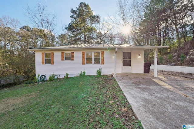 ranch-style home featuring a lawn and a carport