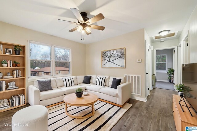 living room featuring ceiling fan and dark hardwood / wood-style flooring