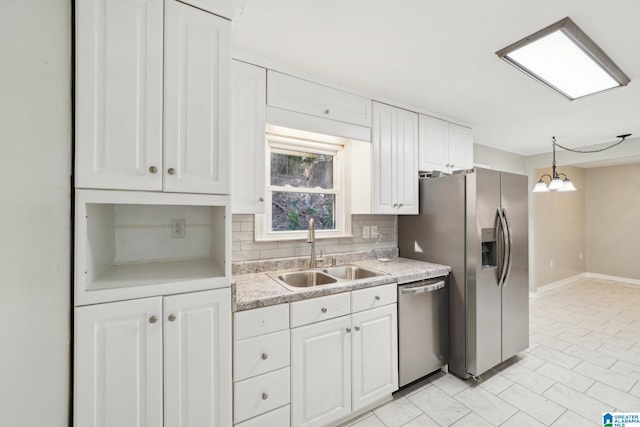 kitchen featuring white cabinetry, sink, decorative light fixtures, decorative backsplash, and appliances with stainless steel finishes