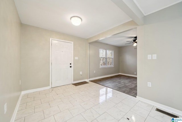 foyer entrance with ceiling fan and beamed ceiling