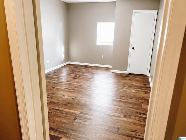 empty room with dark hardwood / wood-style flooring