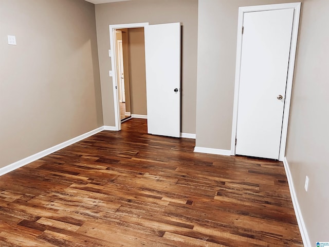 unfurnished bedroom with dark wood-type flooring