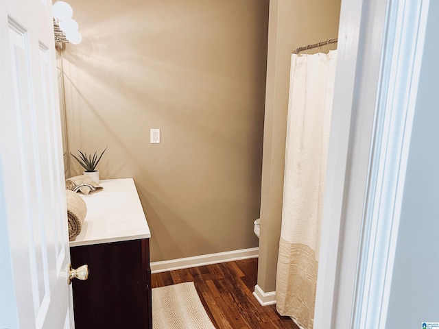 bathroom featuring vanity, wood-type flooring, and toilet