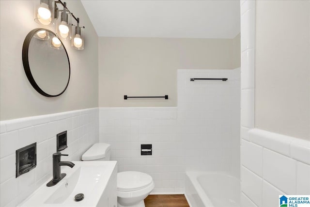 bathroom with vanity, tile walls, toilet, hardwood / wood-style flooring, and a bathing tub