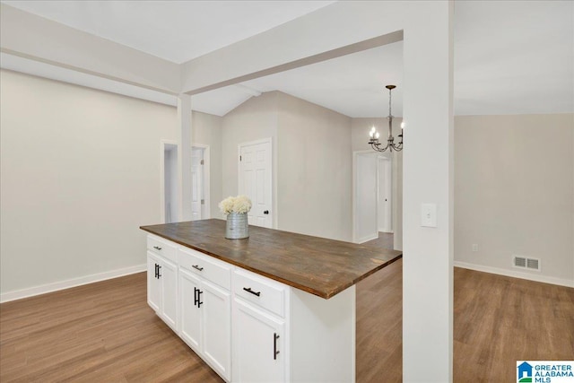 kitchen featuring wooden counters, pendant lighting, an inviting chandelier, white cabinetry, and light wood-type flooring