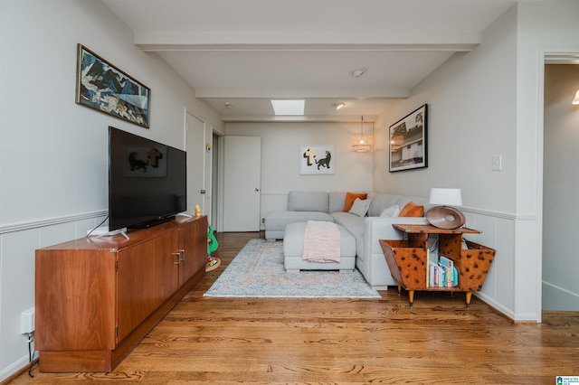 living room with beamed ceiling and light hardwood / wood-style floors