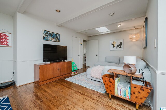 living room featuring beamed ceiling and hardwood / wood-style floors