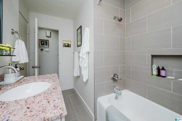 bathroom featuring vanity, tile patterned floors, and tiled shower / bath