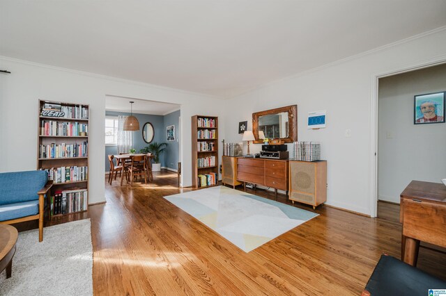 living area with hardwood / wood-style flooring and crown molding