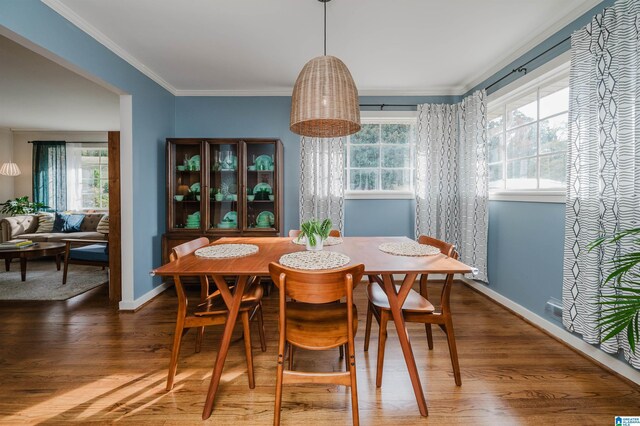 dining room with a healthy amount of sunlight, dark hardwood / wood-style floors, and crown molding