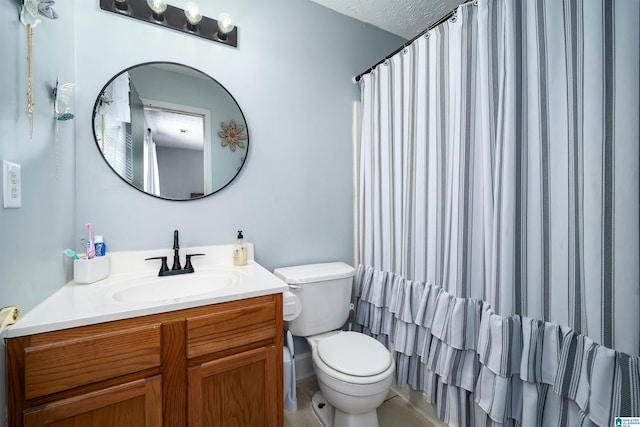 bathroom with vanity, a textured ceiling, and toilet