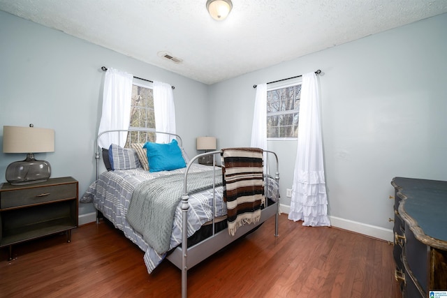 bedroom featuring a textured ceiling and dark wood-type flooring