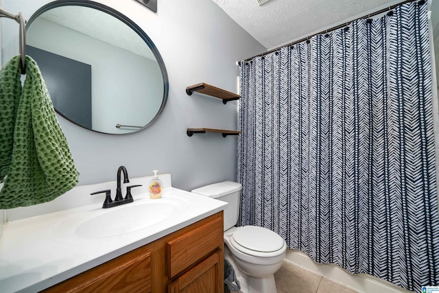 bathroom with tile patterned floors, vanity, toilet, and a textured ceiling