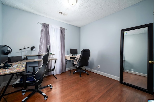 home office with wood-type flooring and a textured ceiling