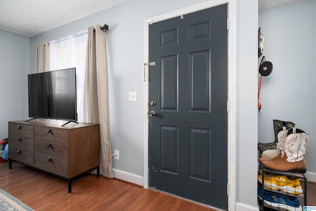 entryway with hardwood / wood-style floors and a textured ceiling