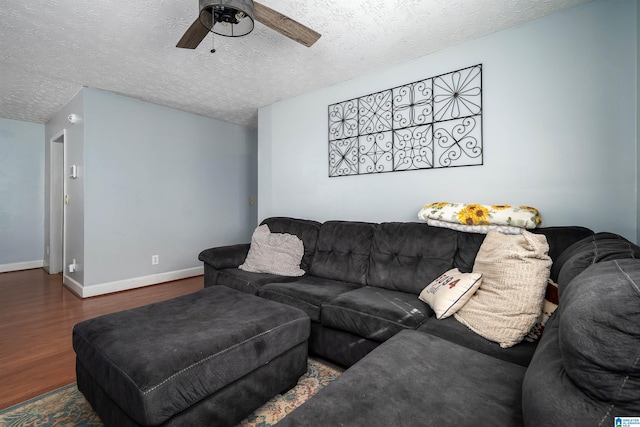 living room featuring a textured ceiling, ceiling fan, and dark wood-type flooring