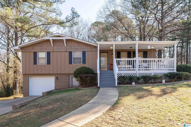 view of front of property featuring a porch, a garage, and a front yard