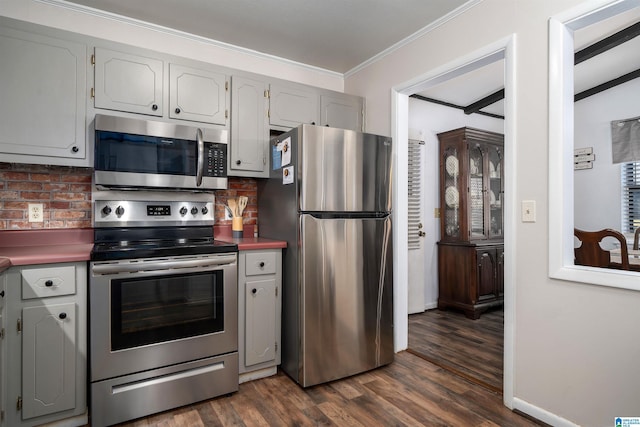 kitchen featuring appliances with stainless steel finishes, tasteful backsplash, crown molding, and dark wood-type flooring