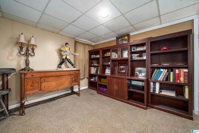 interior space with a drop ceiling and light colored carpet