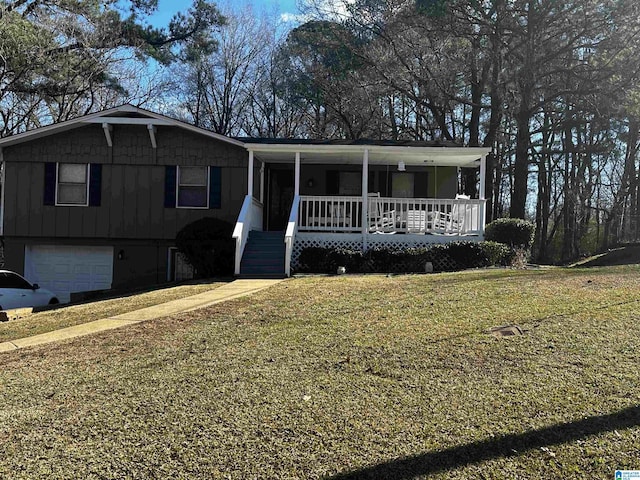 view of front of property with a front yard, a porch, and a garage